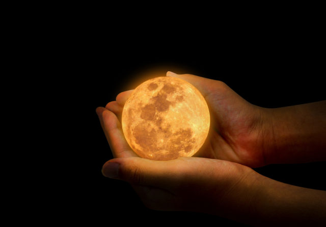 Woman holding a full moon
