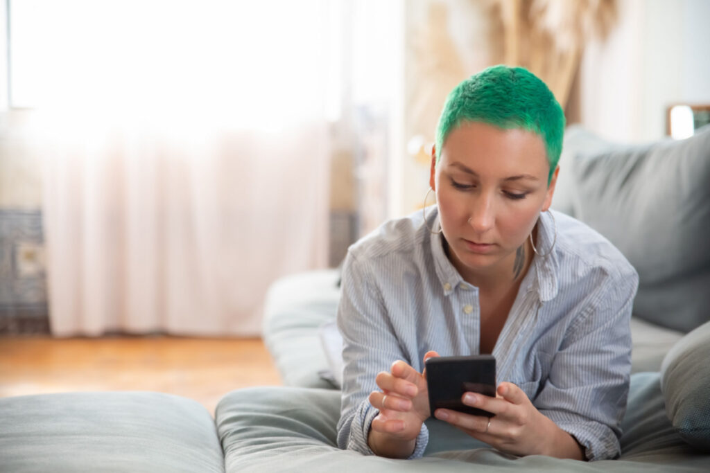 Woman with green hair texting 