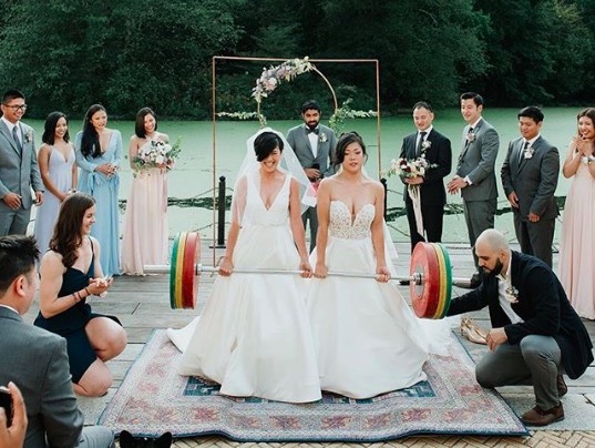 Couple deadlifts at wedding