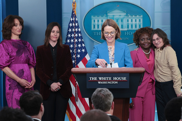 Jennifer Beals in purple, Kate Moenig in black, leisha hailey in blue, Karine Jean-Pierre in fuscia, and Ilene Chaiken in beige all at the white house podium