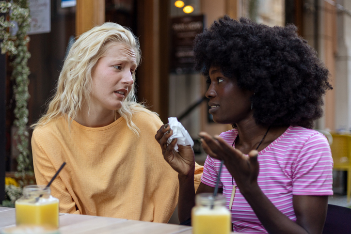 Photo of lesbian couple having a stressful conversation in a cafe