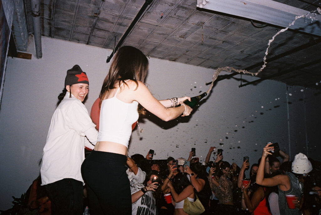 Caroline Hetzel and Emma DiMarco soak the party in champagne. Photo Courtesy of House Party.