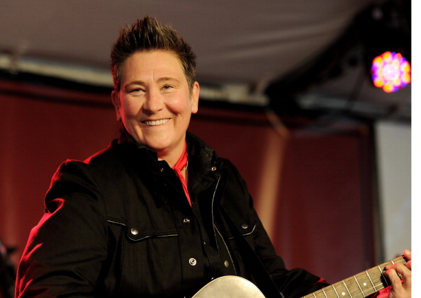 KD Lang smiles while holding a guitar