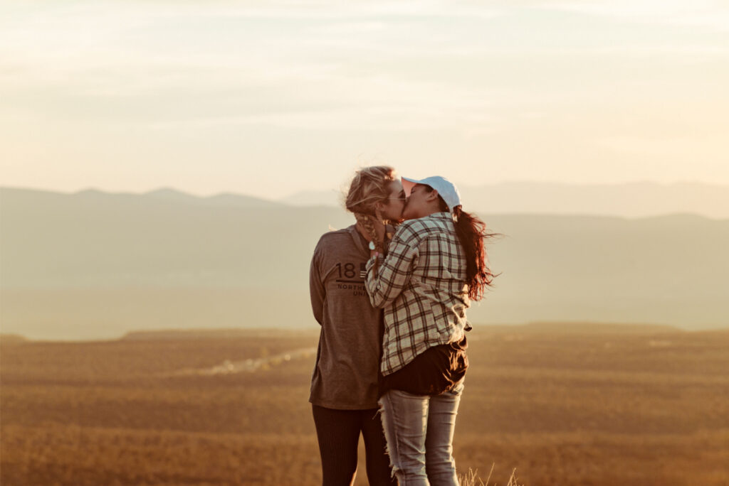 Two women share a romantic kiss against a stunning sunset backdrop in Young, Ariz. Photo by Quintin Gellar/Pexels
