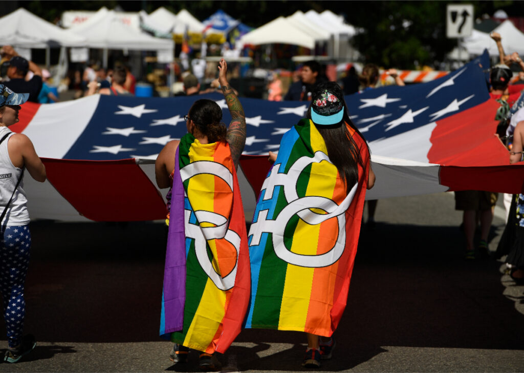 Two women, adorned in lesbian flags take part in the annual Denver PrideFest parade. Photo by Helen H. Richardson/The Denver Post via Getty Images