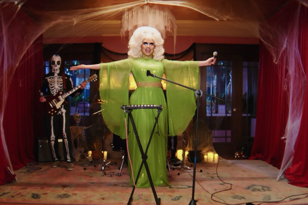 trixie wears a green dress on stage